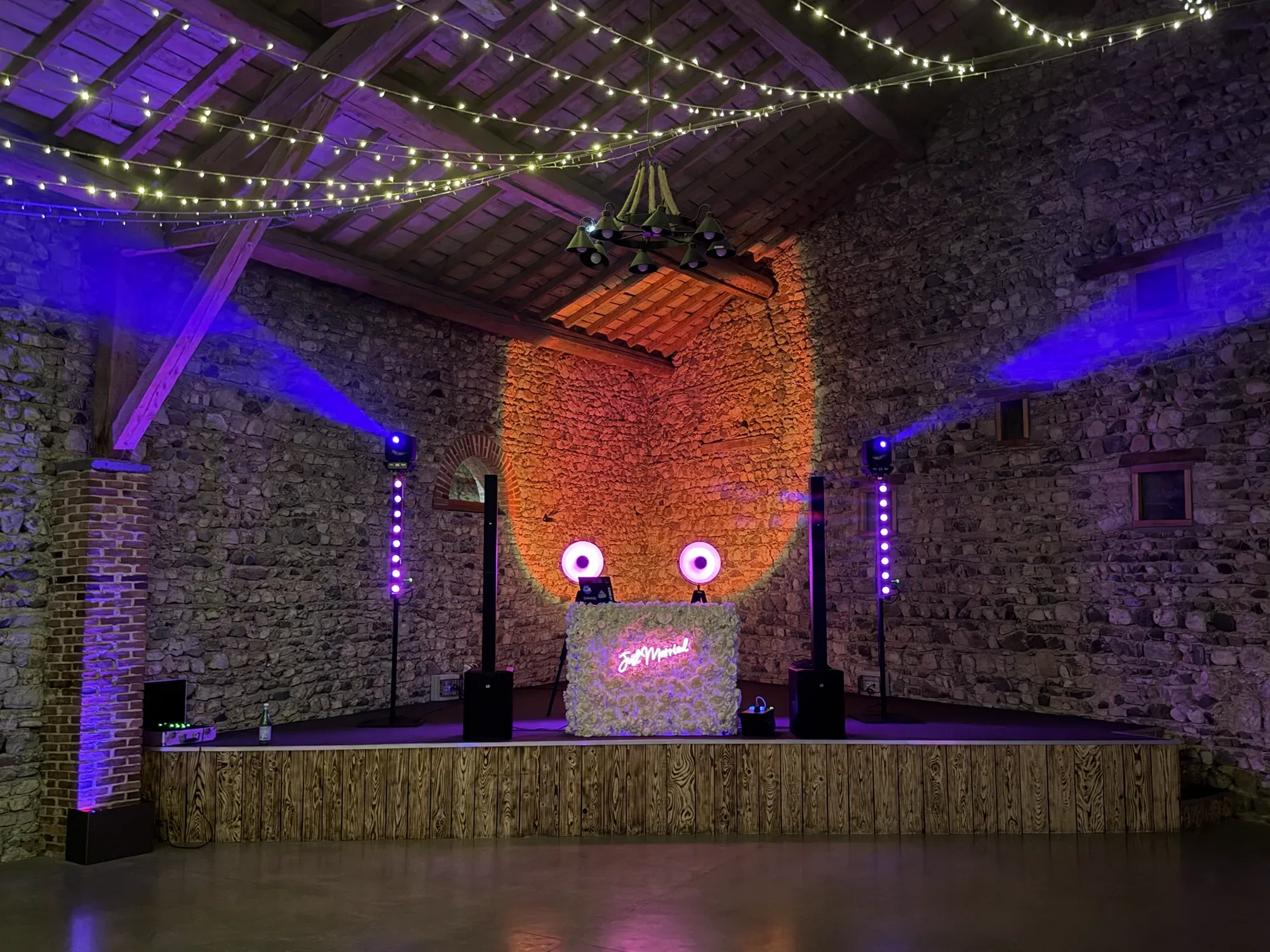 Installation DJ au Château de Gondole, au Cendre : pupitre en fleurs blanches « Just Married », enceintes et barres LED violettes