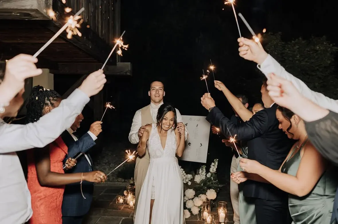 Les mariés arrivent de nuit entre deux haies d’invités qui lèvent des cierges magiques ; la mariée rit, le marié juste derrière elle